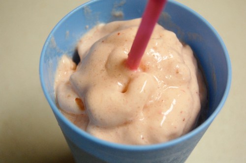 Fruit smoothie in blue cup with a straw