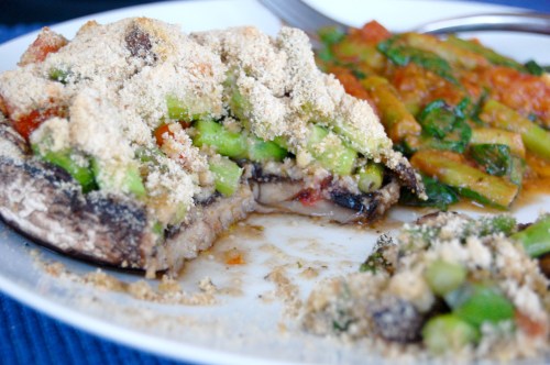 Stuffed portobello with section cut out on plate with side dish